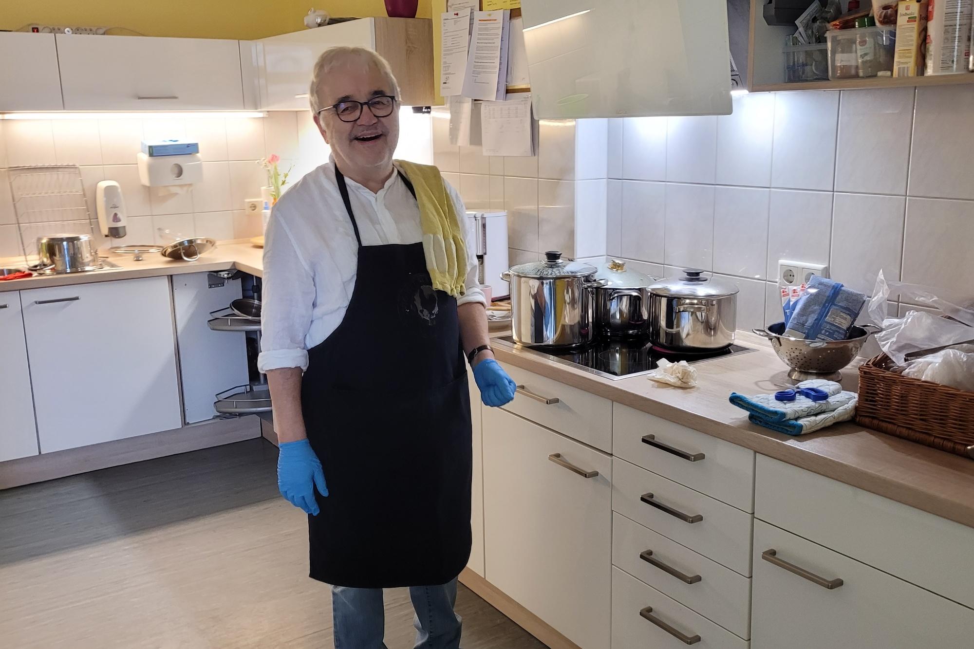 Ehrenamtlicher Mitarbeiter kocht für Besucher vom Tagescafe