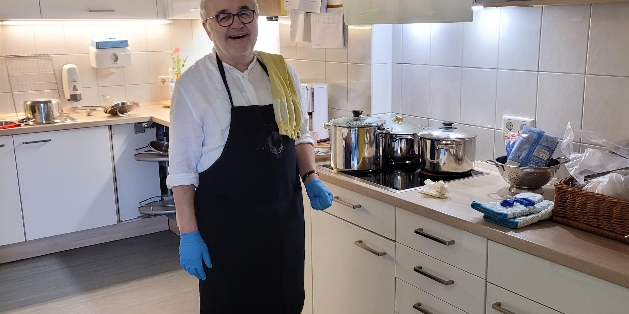 Ehrenamtlicher Mitarbeiter kocht für Besucher vom Tagescafe